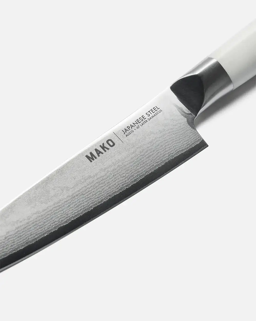 Close-up of Mako Japanese steel utility knife blade with 67 layer Damascus pattern and white handle