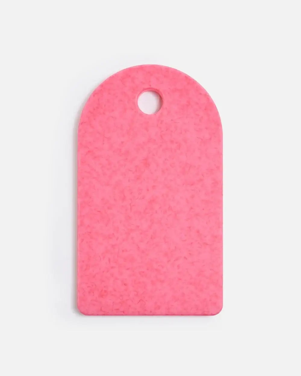 Pink textured cutting board with rounded top and hanging hole, culinary tool by Marion Grasby