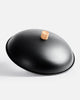 Matte black wok lid with wooden knob, minimalist kitchenware design by Marion Grasby