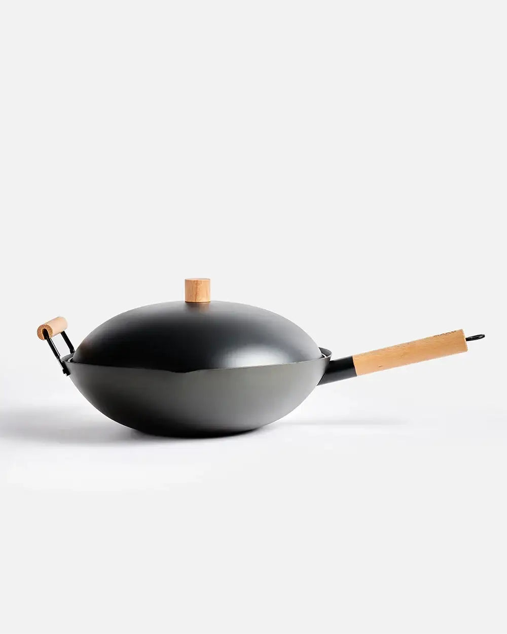 Black wok with wooden handles and lid knob, minimalist kitchen cookware by Marion Grasby