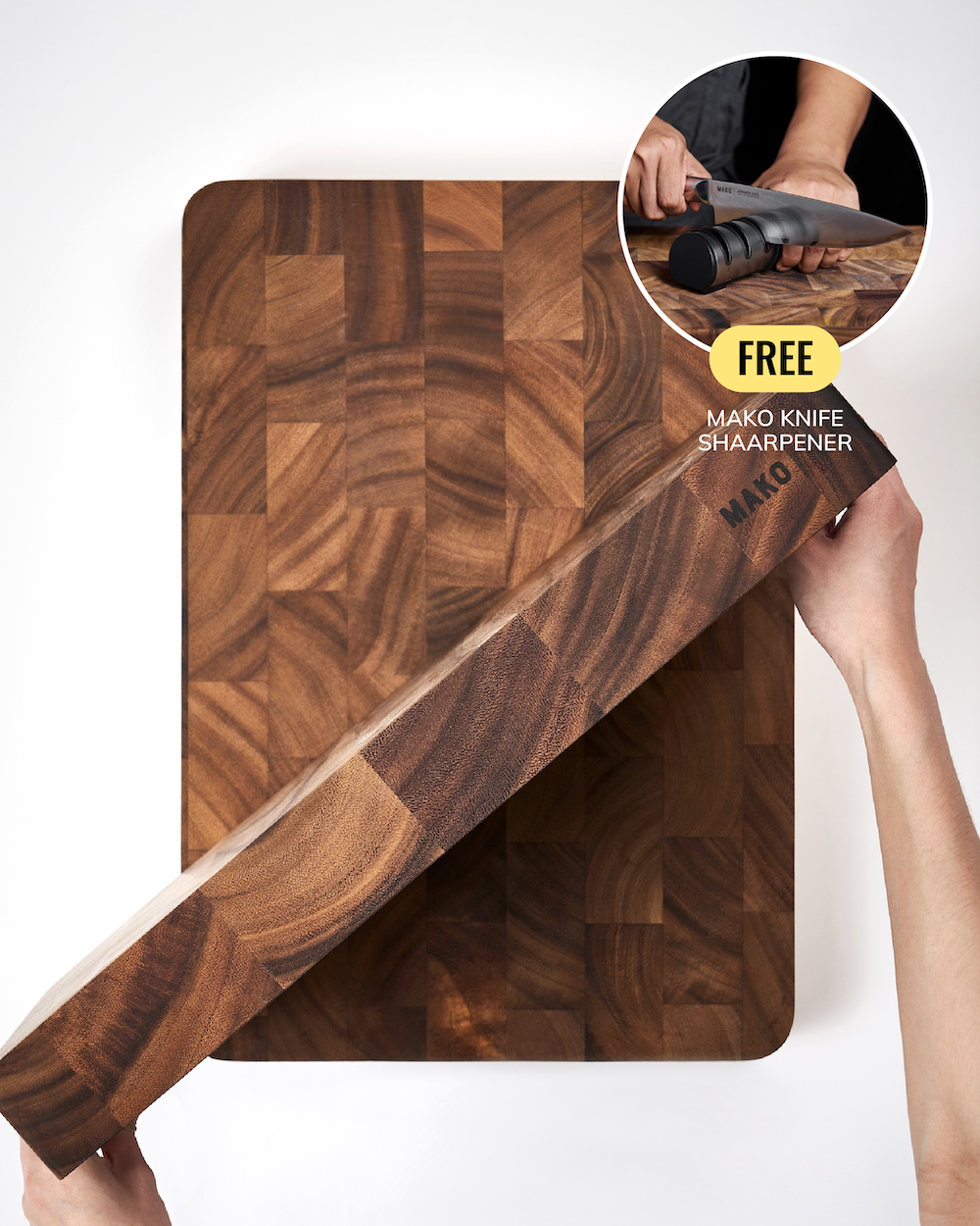 A person holds a long wooden cutting board at an angle over a larger matching wooden board, with a circular inset showing hands sharpening a knife. Text on the inset reads 'FREE MAKO KNIFE SHAARPENER' and the board shows the MAKO brand.