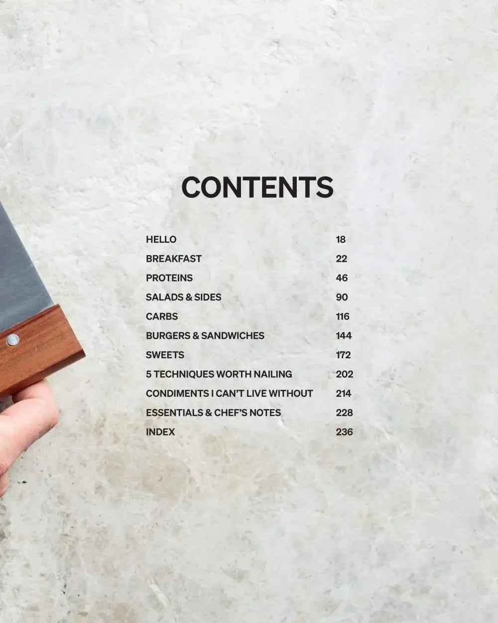 Cookbook contents page with categories like breakfast, proteins, salads, sweets, and chef's notes on marble background