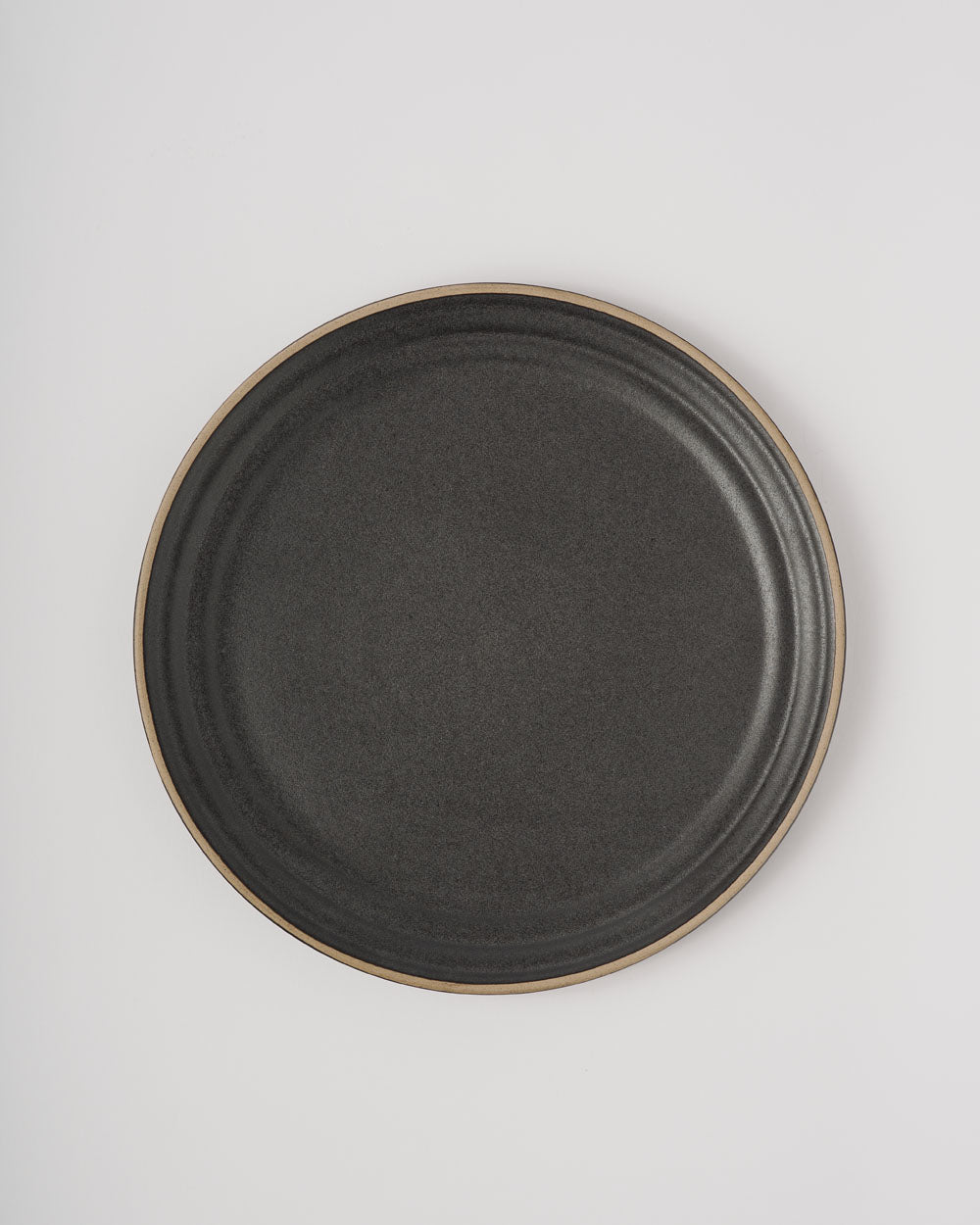 Anaya Charcoal Dinner Plate Set of 4 featuring elegant matte charcoal stoneware dinner plates with natural clay rim detail, photographed from above on white background. Each plate showcases a sleek modern design with subtle textural variations in the handcrafted finish.