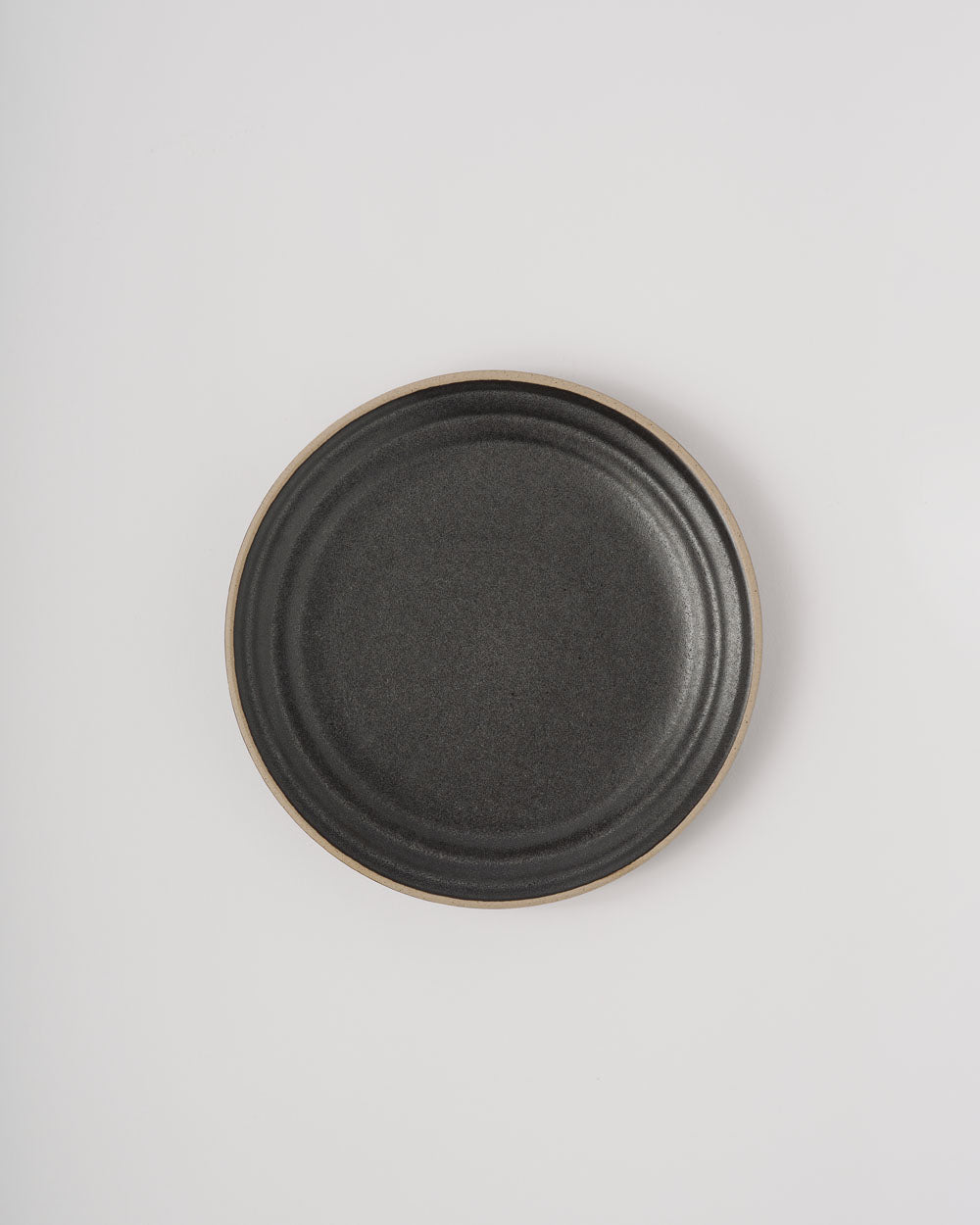 Anaya Charcoal Complete Dinnerware Set featuring a modern dinner plate in deep charcoal grey with subtle concentric rings and natural clay rim detail, photographed on a white background showcasing its elegant minimalist design and premium ceramic craftsmanship