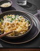 Creamy pasta with grated cheese and parsley served in Asoke charcoal dinnerware by Marion Grasby