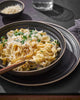 Creamy pasta with grated cheese and parsley served in Asoke charcoal dinnerware by Marion Grasby