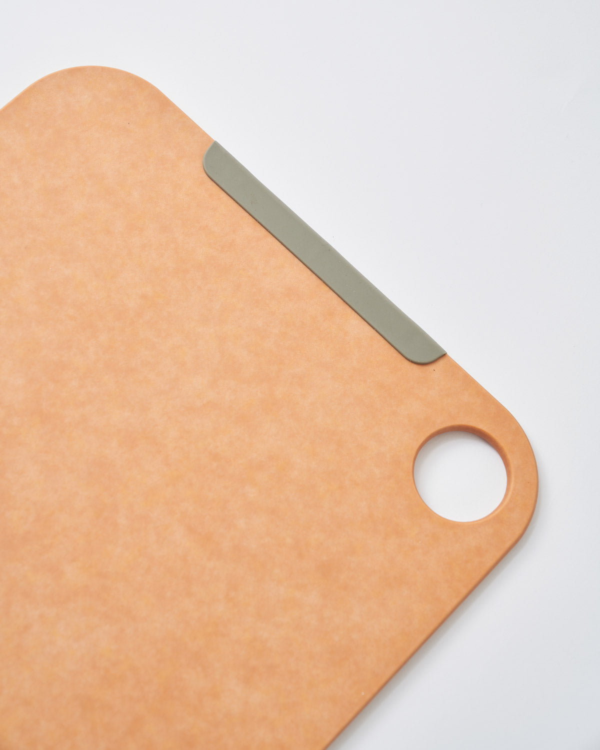 Non-slip wood fibre chopping board with rounded edges and hanging hole on white background