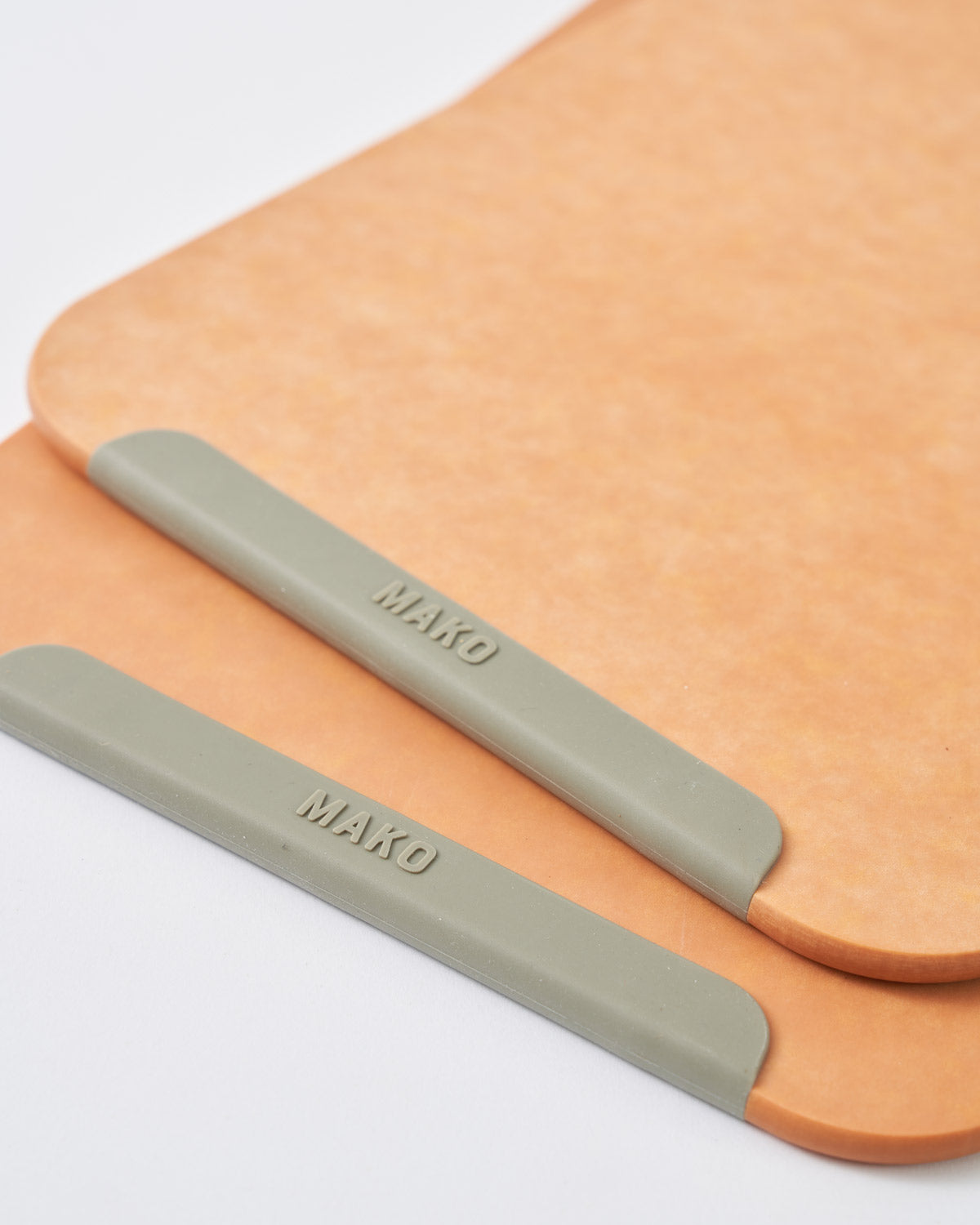 Set of two small wood fibre chopping boards with non-slip grey edges on white background