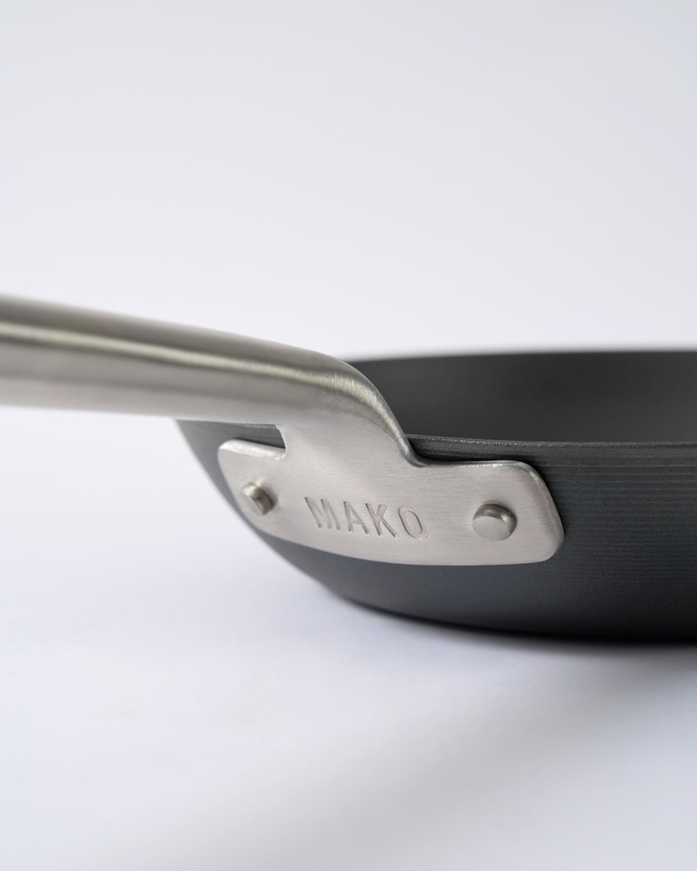 Close-up of black steel frying pan with metal handle and MAKO engraved on the base