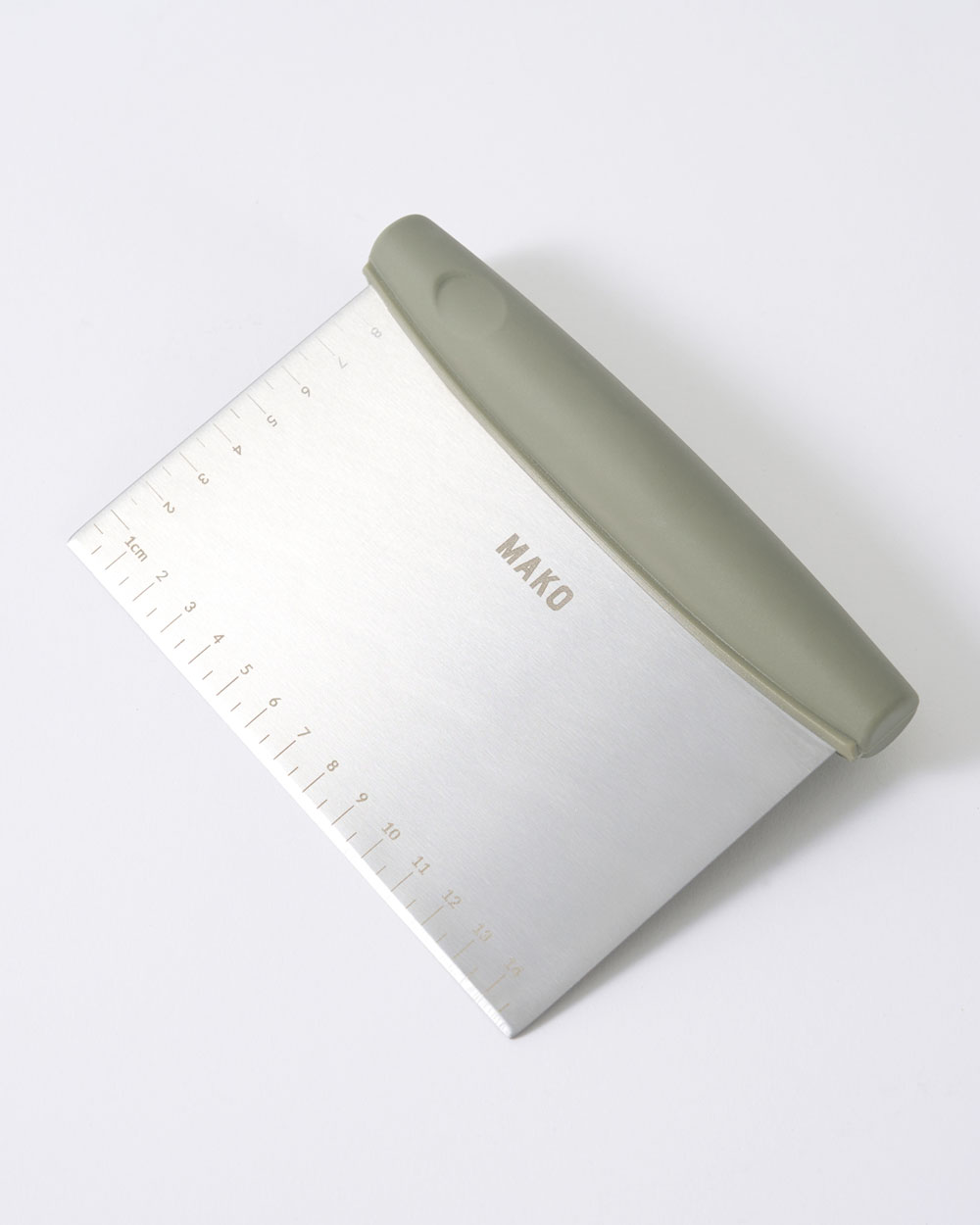 Stainless steel kitchen bench scraper with ruler markings and ergonomic handle on white background.