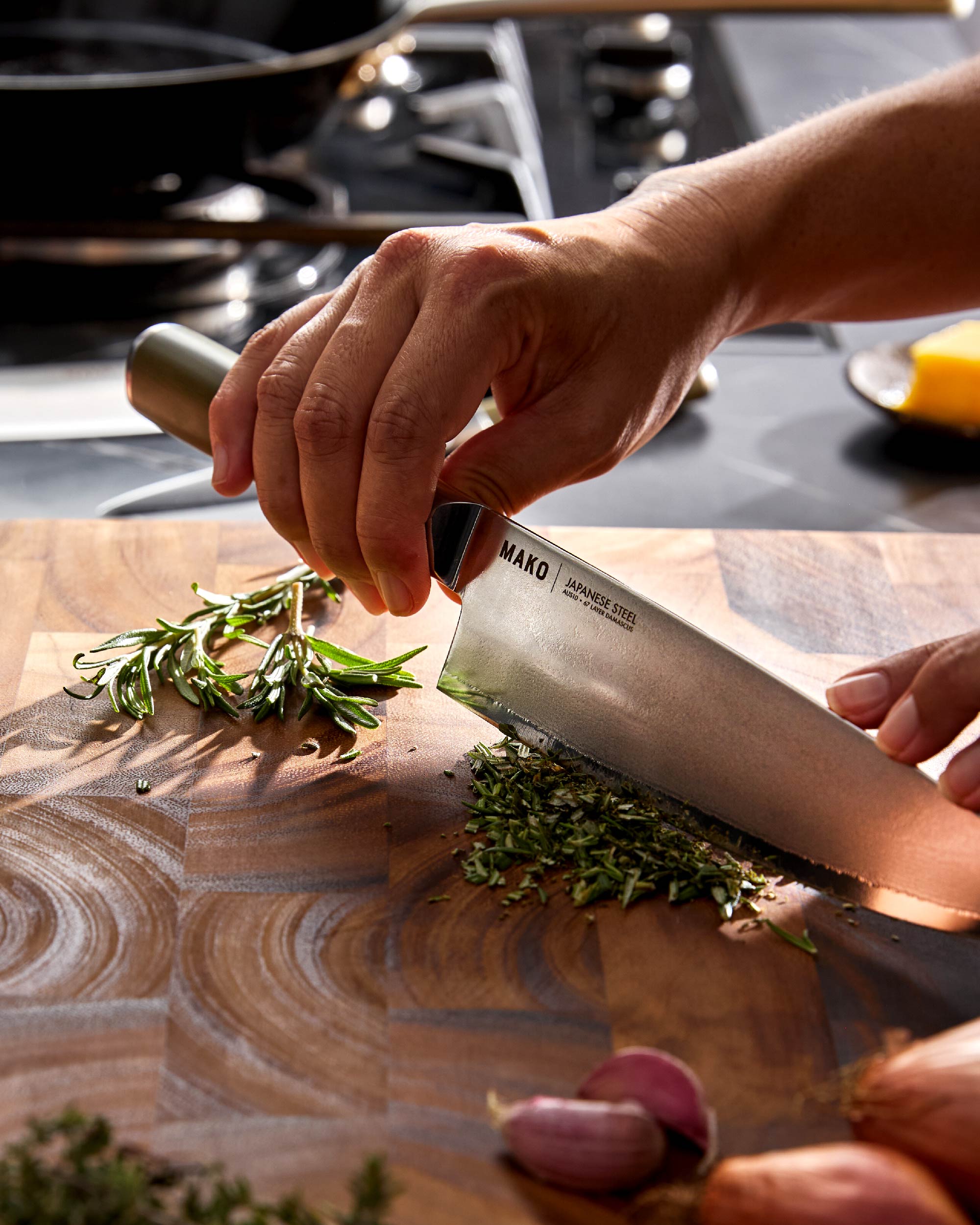 Chopping fresh herbs on a wooden cutting board with a Japanese steel chef knife