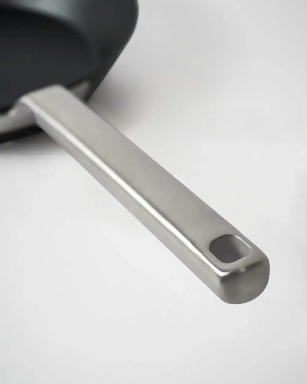 Close-up of Mako black steel mini sear pan with sleek stainless steel handle on white background