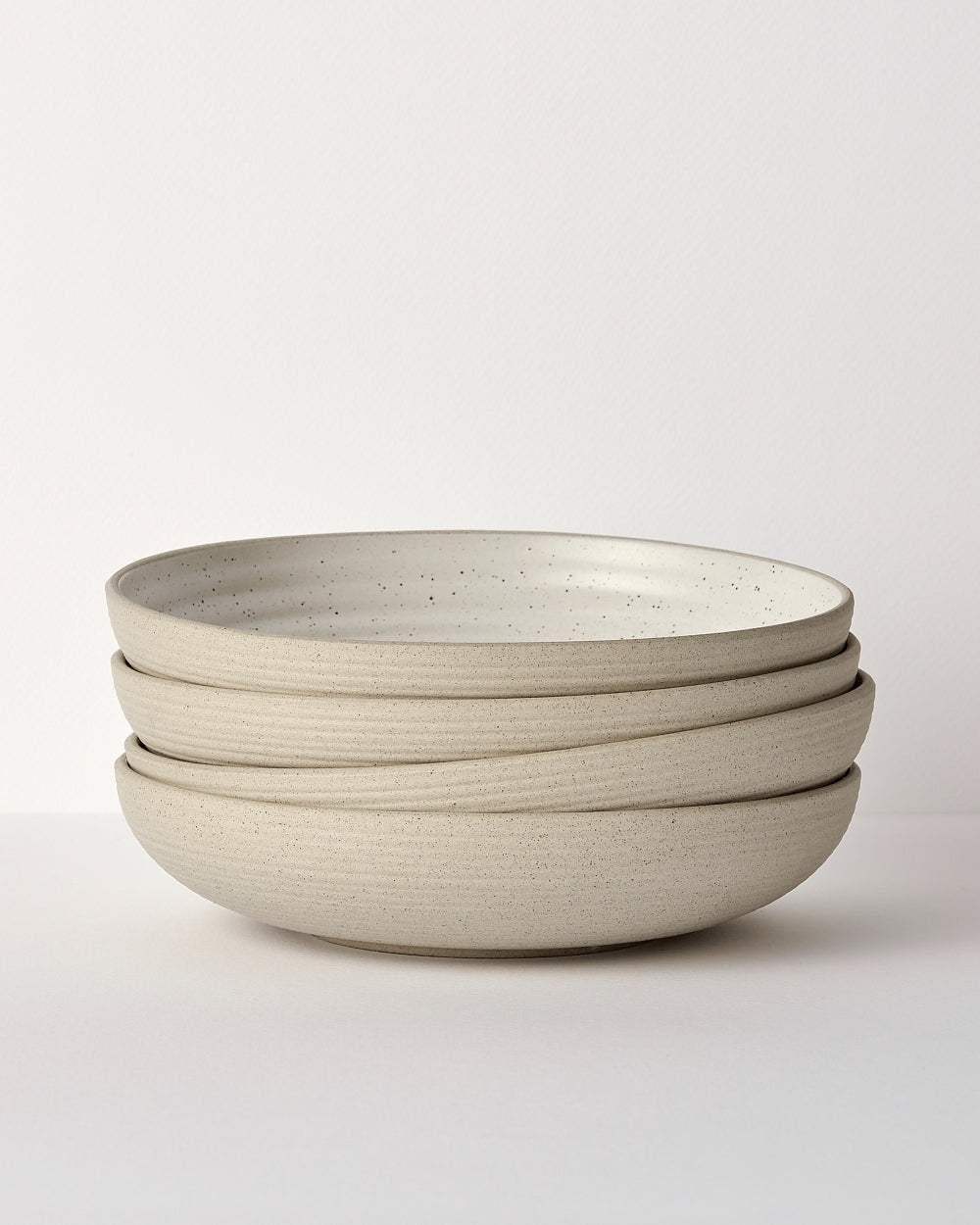 Stack of three beige speckled ceramic dinner bowls from Marion Grasby's Asoke dinnerware set
